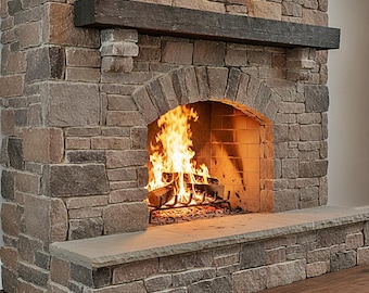 May include: A stone fireplace featuring a dark brown wooden mantel, an arched firebox opening, and a flat stone hearth. Inside the firebox, a metal grate holds burning logs with bright orange and yellow flames against a light brick interior.