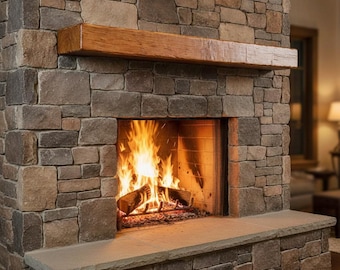 May include: A fireplace constructed from multi-toned rectangular and square stones in shades of gray, tan, and brown. A thick, horizontal wooden mantelpiece sits above the firebox, which contains a burning fire with bright orange flames.