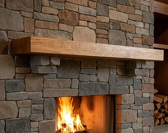 May include: A rectangular wooden fireplace mantel with a visible grain pattern mounted above a stone fireplace. The fireplace features a fire burning with orange and yellow flames inside a firebox surrounded by multi-colored stacked stones.