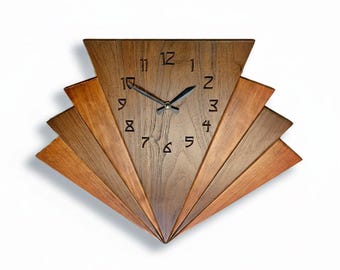 May include: A wall clock crafted from brown wood with a fan-shaped design. The clock face is triangular with dark brown hour and minute hands. The numbers one through twelve are carved into the wood surface in a dark, angular font.