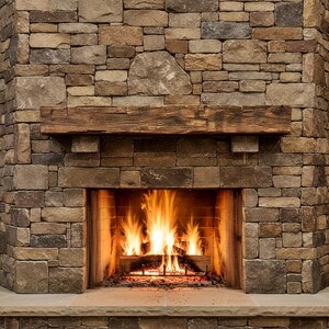 May include: A stone fireplace featuring a rustic, dark brown wooden mantelpiece mounted above a firebox. The hearth is constructed from light tan stone blocks, while the surrounding wall is built from multi-colored, textured natural stones.