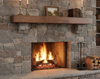 May include: A stone fireplace with a natural wood mantel, featuring a burning fire in the hearth. The mantel holds two brass candlesticks with white candles, a framed landscape painting, a row of books, and a single brass candlestick with a candle.