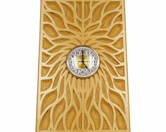 May include: A rectangular light-colored wooden wall clock featuring a layered, laser-cut leaf or petal pattern radiating from the center. The clock face is circular with a gold-toned center, black numerals, and black hands set against a white background.