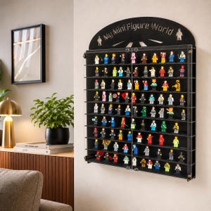 May include: A black wall-mounted display case with ten horizontal shelves holding numerous small plastic toy figures. The arched top features the text "My Mini Figure World" with two figure icons. The case has a clear front panel with two doors.
