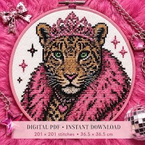 Könnte beinhalten: Ein Kreuzstichmuster in einem runden Stickrahmen mit einem Leoparden, der eine rosa Krone und einen rosa Pelzkragen trägt, mit grünen Augen und einem Herzanhänger. Der Text lautet: DIGITAL PDF • INSTANT DOWNLOAD 201 x 201 stitches • 36.5 x 36.5 cm.