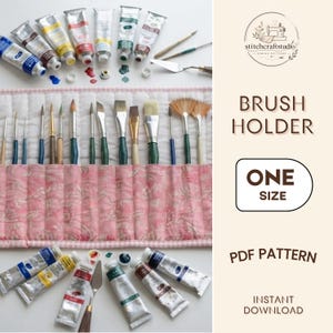 Puede incluir: Un estuche de tela acolchada para pinceles con un patrón floral rosa, que contiene varios pinceles con mangos de madera y de colores. El conjunto incluye varios tubos de pintura de metal, una espátula y el texto BRUSH HOLDER ONE SIZE PDF PATTERN.