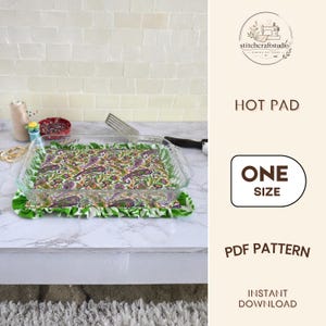 May include: A rectangular fabric hot pad featuring a vibrant paisley pattern in shades of purple, green, and orange with a ruffled green and white border. A clear glass baking dish sits on top of the hot pad. Text reads: STITCHCRAFTSTUDIO HOT PAD ONE SIZE PDF PATTERN INSTANT DOWNLOAD.