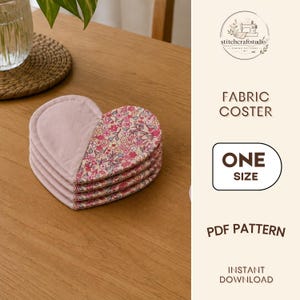 Op de afbeelding: Een stapel hartvormige stoffen onderzetters met een effen oudroze kant en een kant met een bloemenpatroon in roze, rode en witte kleuren. De tekst rechts luidt STITCHCRAFTSTUDIO, FABRIC COSTER, ONE SIZE, PDF PATTERN, INSTANT DOWNLOAD.