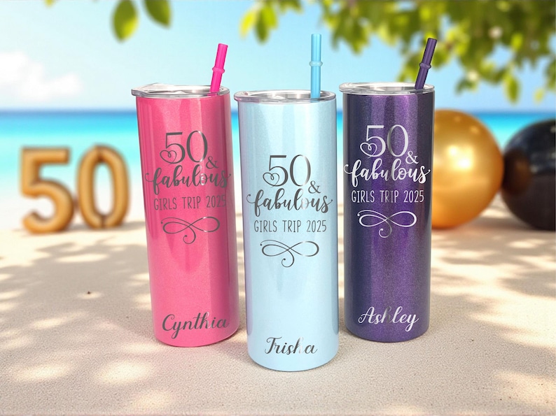 K&ouml;nnte beinhalten: Drei personalisierte Becher mit Strohhalmen in Pink, Hellblau und Lila. Jeder Becher tr&auml;gt den Text "50 & fabulous GIRLS TRIP 2025" und einen Namen. Der Hintergrund zeigt eine Strandszene und einen goldenen Ballon.