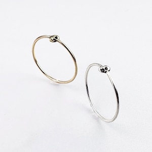 Puede incluir: Dos anillos simples con un dise&ntilde;o de calavera. Un anillo es de oro y el otro es de plata.