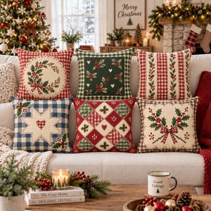 May include: A set of six square throw pillows featuring various holiday-themed patterns including red and white gingham, green holly leaf prints, and cream-colored centers with embroidered wreaths, stars, and bows on a light-colored sofa.
