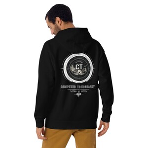 May include: A black hooded sweatshirt featuring a white graphic on the back. The design includes a circular target-like element surrounding a medical CT scan image, with the text CT, COMPUTED TOMOGRAPHY, and LAYER BY LAYER printed below.