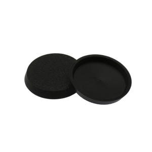 May include: Two circular black plastic caps with a textured top surface and a smooth, recessed interior. These components feature a raised outer rim and a flat base, designed as protective covers or end caps for cylindrical objects or tubing.