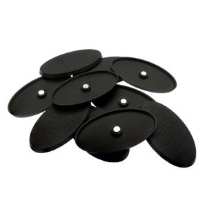 May include: A collection of black oval-shaped plastic bases for miniature figures. Each base features a textured top surface and a small, circular silver-coloured magnet embedded in the centre of the underside, designed for stability and display.