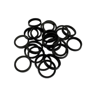 May include: A collection of numerous black circular rings arranged in a scattered pile. Each ring features a consistent thickness and a smooth, matte finish, creating a uniform appearance across the entire group of individual circular components.