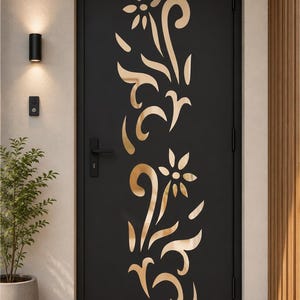 May include: A matte black rectangular door featuring a vertical cutout design of two stylised flowers with curved stems and leaves. The cutout reveals a metallic gold finish underneath the door surface. It includes a black handle and hinges.