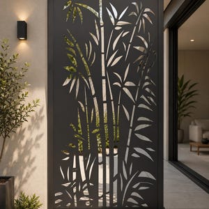 May include: A tall, rectangular, matte black metal privacy screen featuring a laser-cut design of bamboo stalks and leaves. The screen is framed with a solid border and stands vertically, creating a decorative barrier with open cutouts.