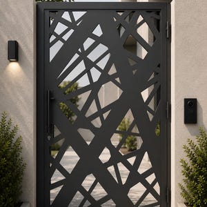 Puede incluir: Una puerta de metal negro mate con un patrón geométrico abstracto de líneas que se cruzan y formas irregulares. La puerta incluye un tirador vertical, un mecanismo de cerradura con llave y está montada entre dos pilares de piedra clara.