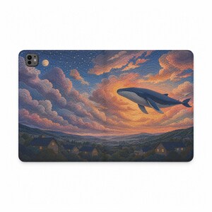 Pode incluir: Uma capa retangular para tablet com uma ilustração impressa de uma grande baleia azul nadando através de um céu ao pôr do sol cheio de nuvens rosas e laranjas sobre uma paisagem de pequenas casas situadas num vale sob um céu estrelado.