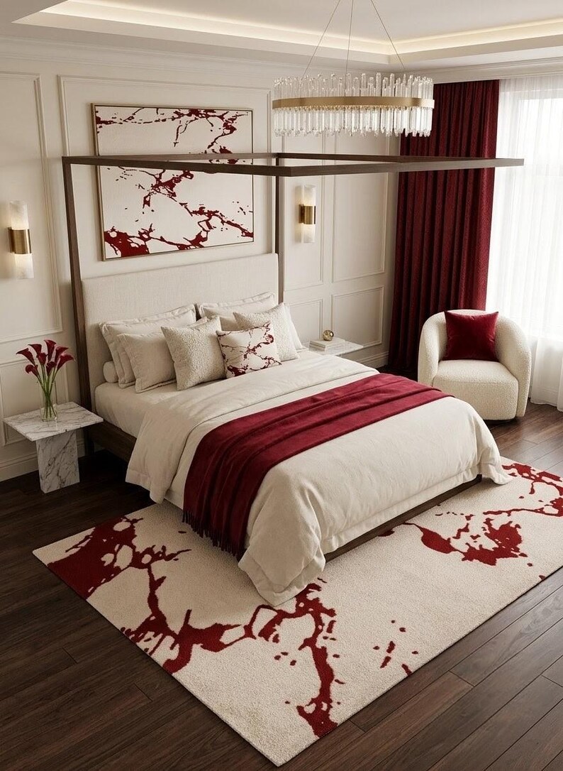 Puede incluir: Un dormitorio con una cama con dosel de marco color crema, ropa de cama blanca y una manta roja oscura. Una alfombra a juego con un patr&oacute;n de m&aacute;rmol rojo se encuentra en el suelo, complementada por una obra de arte mural con un dise&ntilde;o similar.