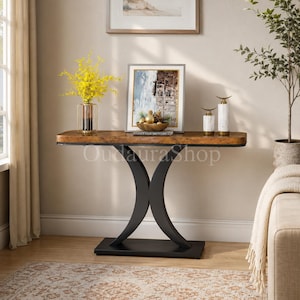 May include: A rectangular console table with a rustic brown wood-grain top and a black metal base featuring two curved, crescent-shaped legs connected to a flat rectangular pedestal. The table surface holds a glass vase with yellow flowers.