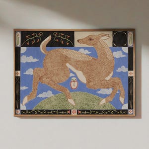 May include: A framed rectangular wall art print featuring a tan deer leaping over a green hill against a blue sky with white clouds. A red apple is centred below the deer. The border contains black panels with floral vines and geometric shapes.