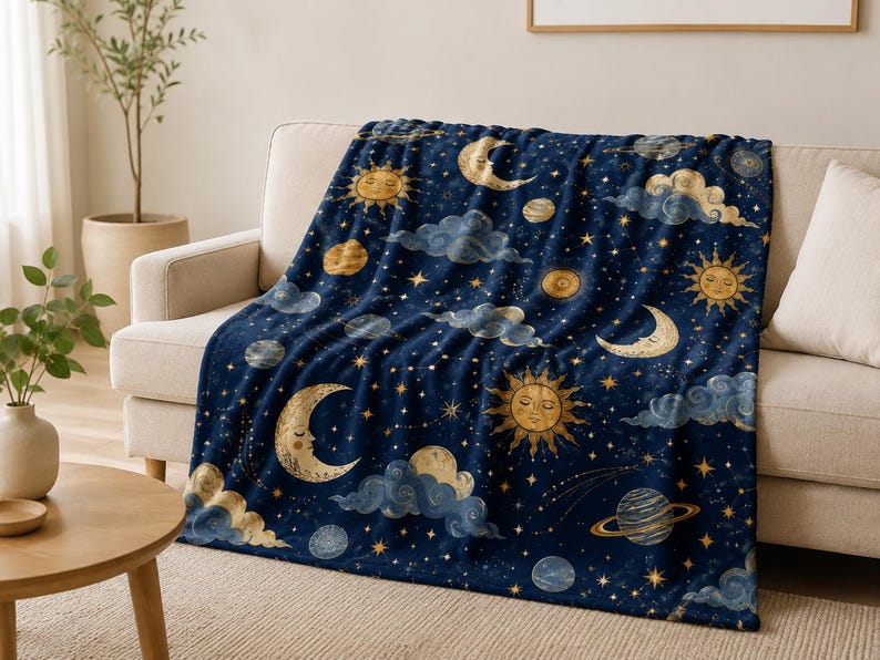以下が含まれることがあります： 顔が描かれた金色の太陽、三日月、輪のある惑星、散りばめられた星々が描かれた紺色のスローケット。生地の表面全体に、柔らかくぼやけた青い雲が点在する天体模様がデザインされています。