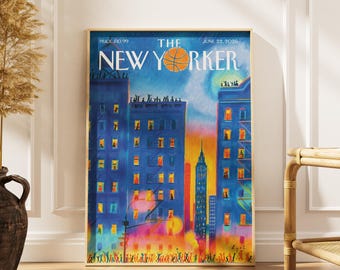 Può includere: Una stampa incorniciata della copertina della rivista The New Yorker datata 22 giugno 2026. L'opera raffigura una vivace scena urbana al crepuscolo con edifici blu, finestre illuminate, una grafica di un pallone da basket e una folla.