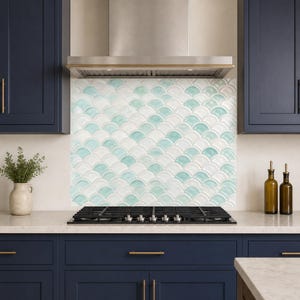 May include: A kitchen backsplash featuring a repeating fan-shaped or fish-scale tile pattern in alternating shades of glossy white and soft seafoam green. The tiles are arranged in a uniform, overlapping layout behind a black gas stovetop.