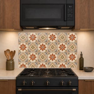 May include: A kitchen backsplash featuring a repeating pattern of square tiles. Each tile displays a central orange flower motif surrounded by intricate geometric shapes in shades of cream, muted green, and slate blue, creating a cohesive grid.