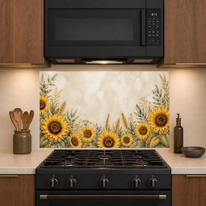 May include: A rectangular kitchen backsplash panel featuring a watercolor illustration of yellow sunflowers, green leaves, and golden wheat stalks against a cream-colored background, positioned behind a black gas stove and microwave.
