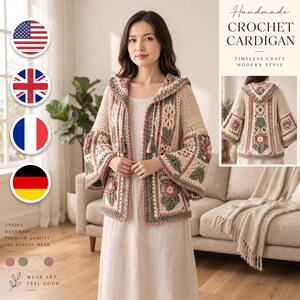May include: A beige crochet cardigan featuring a hood, long flared sleeves, and intricate floral motifs in shades of green and dusty pink. The garment includes a front tie closure with tassels and a detailed back view showing a large central flower pattern.