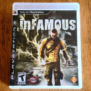 May include: A PlayStation 3 video game case for the title inFAMOUS. The cover art features a character in a yellow jacket surrounded by electrical bolts against a dark, urban background. The case includes the ESRB Teen rating and Sony branding.