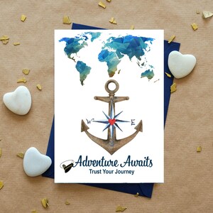 May include: A white greeting card featuring a blue geometric world map above a brown anchor with a compass rose and a small red heart. The text reads Adventure Awaits and Trust Your Journey, accompanied by a small illustration of a captain's hat.