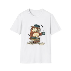 Può includere: Una t-shirt bianca con la grafica di un gufo marrone che indossa un tocco da laureato e occhiali, seduto su una pila di libri etichettati Astrophysics, Calculus, History of Night e Mythology, mentre tiene in mano una tazza con scritto JAVA e vapore.