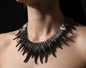 Colar com franjas e spikes em tom de chumbo, joia ousada para um visual punk rock.
