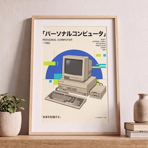 May include: A framed poster featuring a beige vintage personal computer illustration with a keyboard, monitor, and disk drive. The text includes "PERSONAL COMPUTER / 1982", "16-BIT", "640 KB MAX", "RGB COLOR", "JAPAN", "1982", and Japanese characters.
