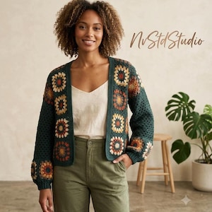 May include: A dark green crochet cardigan featuring a granny square pattern with floral-inspired centers in shades of orange, yellow, and cream. The open-front garment has long sleeves and a solid dark green ribbed trim along the edges and cuffs.