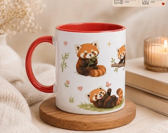 May include: A white ceramic mug with a red interior and handle, featuring illustrations of red pandas, bamboo, and small hearts. The mug has a capacity of 11oz and 325ml, and includes icons indicating it is microwave and dishwasher safe.