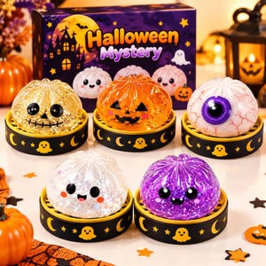Könnte beinhalten: Fünf quetschbare Halloween-Spielzeuge in transparenten, glitzernden und gemusterten Designs, darunter ein Kürbis, ein Augapfel und geisterartige Figuren. Jedes Spielzeug steht auf einem kleinen schwarzen Sockel mit gelben Geistern und Monden.
