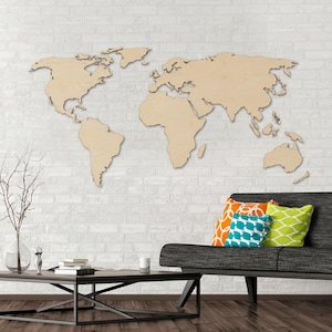 May include: A large, light-coloured wooden world map wall art piece featuring detailed continental outlines. The map is mounted on a white brick wall, displaying the shapes of North America, South America, Europe, Africa, Asia, and Australia.