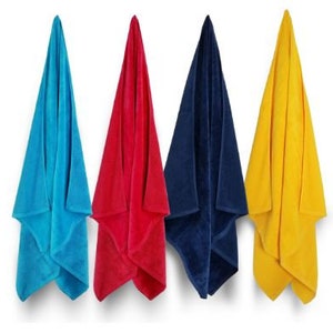 Puede incluir: Cuatro toallas de playa coloridas colgadas sobre un fondo blanco. Las toallas son en tonos azul, rojo, marino y amarillo. Las toallas est&aacute;n dobladas en forma triangular, mostrando su suave textura.