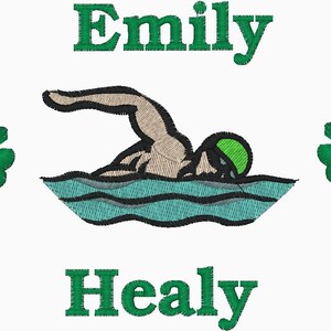 May include: Embroidered design featuring a swimmer in a green cap and goggles, swimming in teal water. The name "Emily Healy" is embroidered in green above and below the swimmer, with green shamrocks on either side.