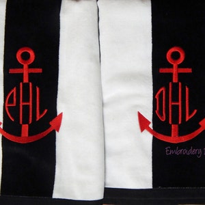 Puede incluir: Dos toallas a rayas blancas y negras con un dise&ntilde;o de ancla bordada en rojo. Cada ancla presenta un monograma en hilo rojo. Las toallas tienen un tema n&aacute;utico, con el texto "Embroidery by Sharon" en la esquina inferior derecha.