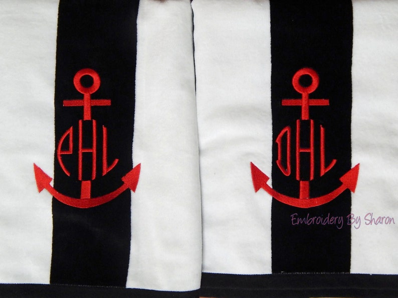 Puede incluir: Dos toallas a rayas blancas y negras con un dise&ntilde;o de ancla bordada en rojo. Cada ancla presenta un monograma en hilo rojo. Las toallas tienen un tema n&aacute;utico, con el texto "Embroidery by Sharon" en la esquina inferior derecha.