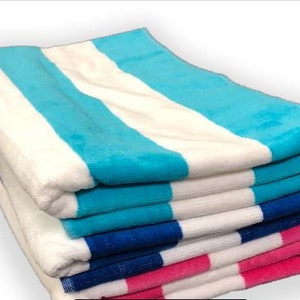 Puede incluir: Una pila de toallas de playa a rayas blancas, azules y rosas. Las toallas est&aacute;n dobladas y apiladas ordenadamente, mostrando los colores vibrantes y la textura suave. Perfectas para un d&iacute;a en la playa o la piscina.