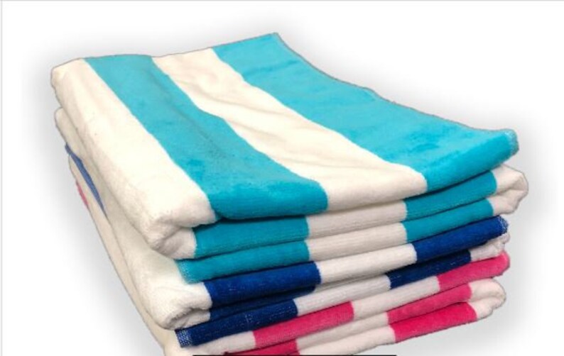 Puede incluir: Una pila de toallas de playa a rayas blancas, azules y rosas. Las toallas est&aacute;n dobladas y apiladas ordenadamente, mostrando los colores vibrantes y la textura suave. Perfectas para un d&iacute;a en la playa o la piscina.