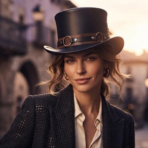 May include: A black top hat featuring a brown leather band adorned with metallic rings and studs. The hat has a structured crown and a curved brim, providing a classic silhouette. It is worn with a dark textured blazer and a light-colored shirt.