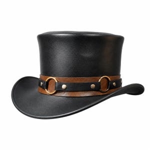 May include: A black top hat featuring a wide brown leather band around the base. The band is accented with a thinner black leather strap, two circular brass-toned metal rings, and small silver-toned metal studs securing the layers together.