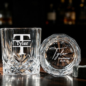 May include: Two clear glass whisky tumblers with a faceted diamond-cut pattern. One glass features a large letter T with the name Tyler centred. The other glass is positioned to show the bottom, engraved with the name Tyler, Groomsman, and 20.09.25.